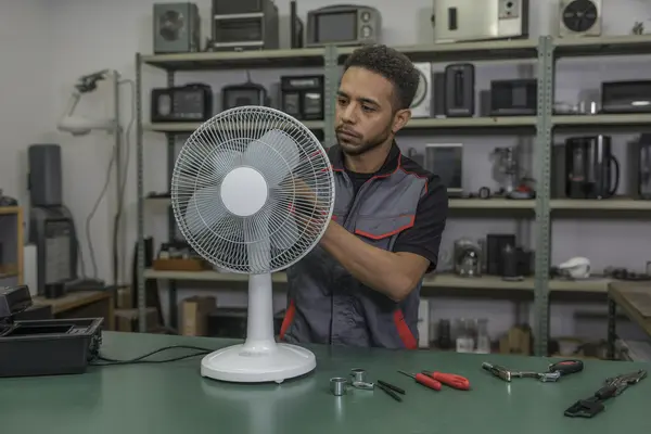 echnician working on a portable electric fan
